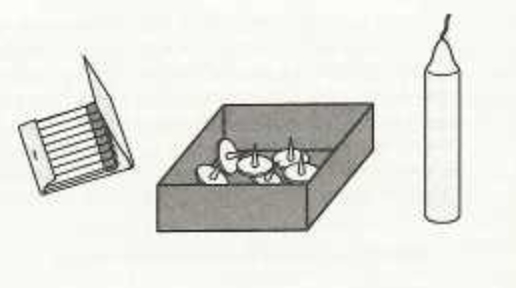 A book of matches, a box of thumbtacks that is open on the top, and a candlestick